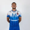 Tricoul de joc al echipei de fotbal Gloria Bistrița, alb cu albastru, văzut din față — sigla uhlsport, lupul pe piept și sponsorul Superbet