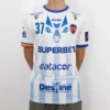 Tricou de joc handbal Gloria Bistrița – Alb (față) Tricou de joc handbal Gloria Bistrița, alb cu accente albastre, văzut din față — sigla Kempa, stema clubului și sponsorii