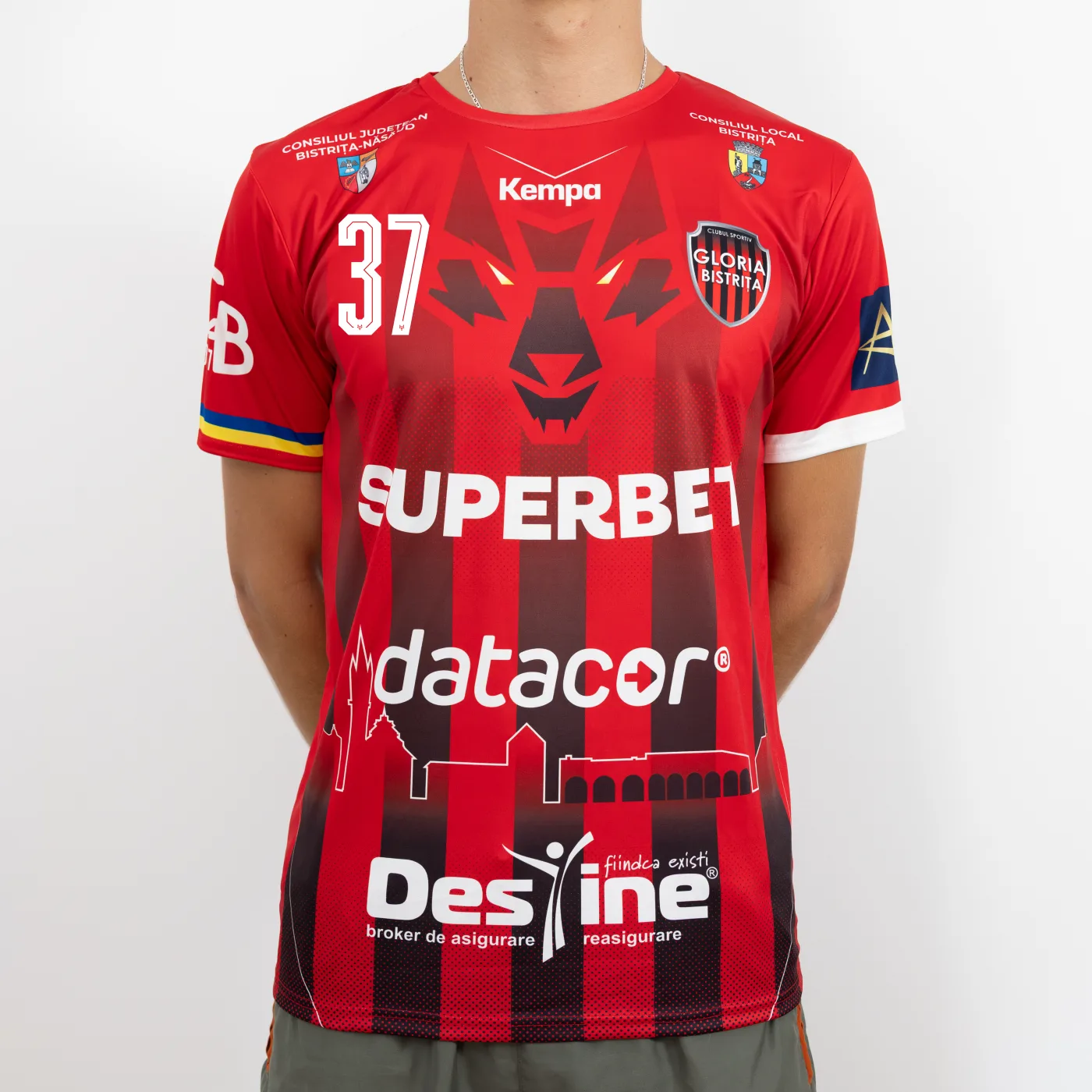 Tricou de joc handbal Gloria Bistrița, roșu cu dungi negre, văzut din față — sigla Kempa, stema clubului și sponsorii Superbet, datacor și Destine