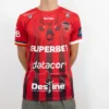 Tricou de suporter Gloria Bistrița – Roșu (față) Tricou de suporter Gloria Bistrița, roșu cu dungi negre, văzut din față — sigla Kempa, stema clubului și sponsorii